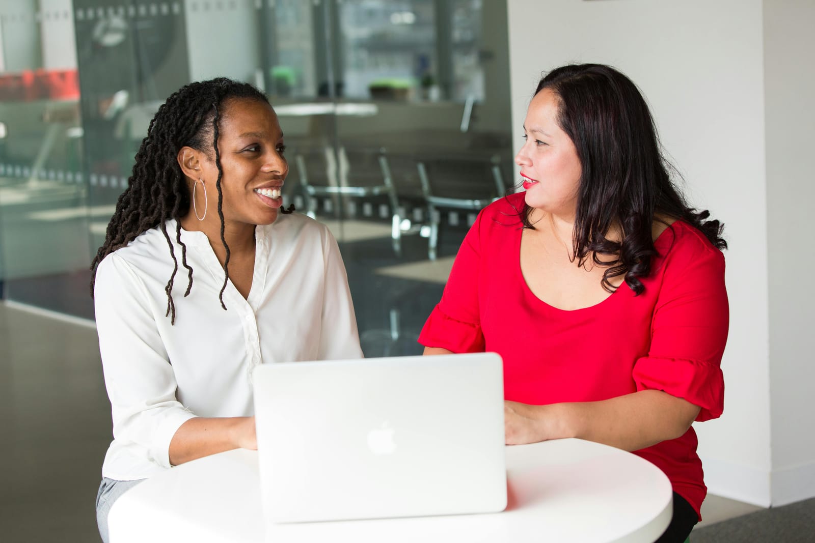 Duas mulheres conversam diante de um notebook, em uma sessão de mentoria de carreira